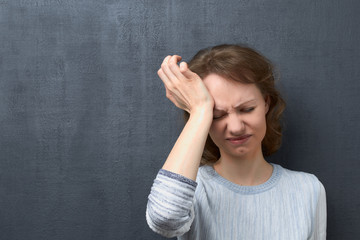 Portrait of unhappy woman suffering from headache