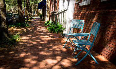 Blue patio chairs on brick sidewalk