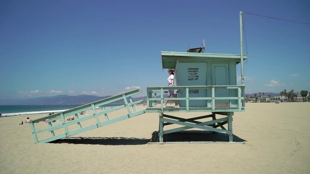 Young girl at the beach. Lifeguard booth