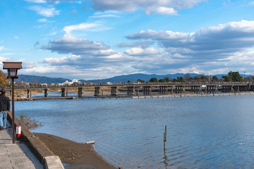 Togetsu-kyo bridge over katsuragawa river with colourful forest mountain background in Arashiyama district. Arashiyama is a nationally designated Historic Site and Place of Scenic Beauty. Kyoto, Japan