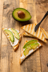 toasts with avocado, on wooden background, delicious breakfast