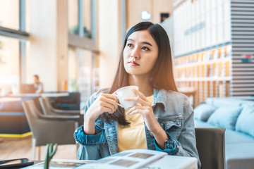 Asian woman in a cafe drinking coffee .Portrait of Asian woman smiling in coffee shop cafe vintage color tone.