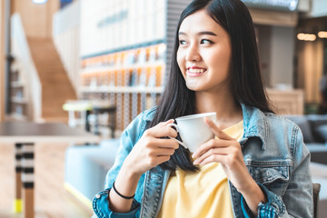 Asian woman in a cafe drinking coffee .Portrait of Asian woman smiling in coffee shop cafe vintage color tone.