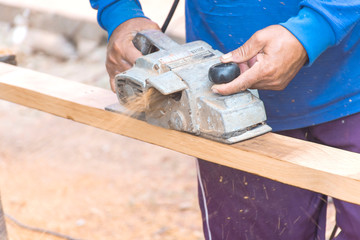 Carpenter is using electric planing machines