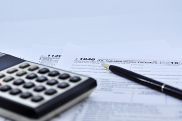 Tax Season: 1040 U.S. Individual Income Tax Return Form Horizontal top right view of an office laptop background with a metallic pen preparation on taxation.