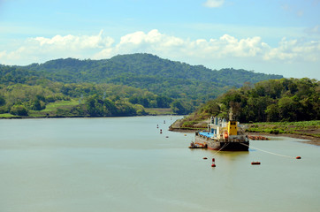 Landscape of the Panama Canal, cargo ship moored to the canal bank. 