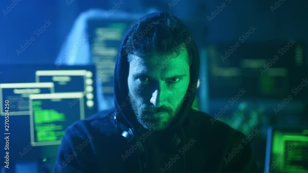 Poster portrait of insidious hacker organizing virus attack on corporate servers in hideout place. serious 