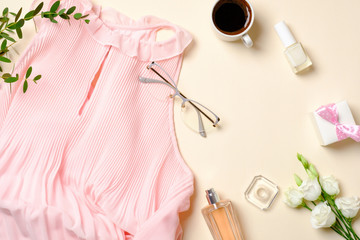 Flat lay feminine accessories, perfume bottle, roses flowers, pink dress, glasses, coffee cup, gift box. Top view beauty blogger desk with female stuff, clothes and cosmetic. Fashion blog banner.
