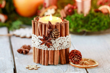 Candle decorated with cinnamon sticks