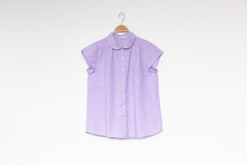  Purple blouse with wooden hanger isolated white background.