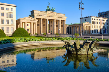 Fototapeta premium The famous Brandenburg Gate in Berlin with reflections in a fountain