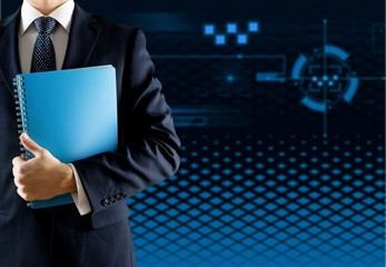 Male businessman with notebook on office background
