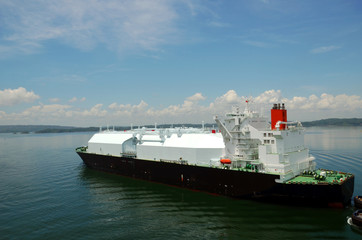 LNG tanker ship transiting through Panama Canal on beautiful sunny day.