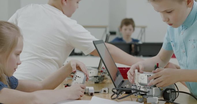 Curious kids working on a functional programable robot during robotics class at school. 4K UHD 60 FPS SLOW MOTION