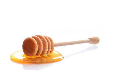Wooden honey dipper with honey isolated on white
