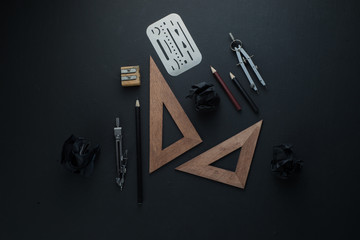 Drawing board flat lay with pencils, compasses, rulers, crumpled paper balls. Dark header for engineering, construction, design with copy space.