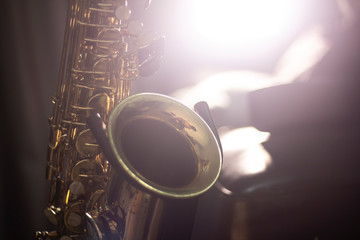 Saxophone on the stand with volume light in the dark background © Naruphon