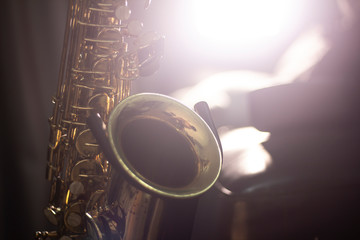 Saxophone on the stand with volume light in the dark background
