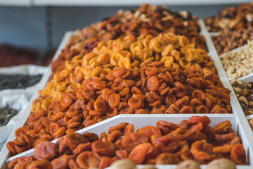 dried fruits and nuts. organic dried dried apricots of different varieties on the shelf of a food store.