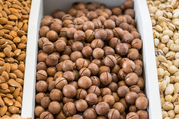organic macadamia nuts in shell. macadamia nuts on the counter of a nut shop.