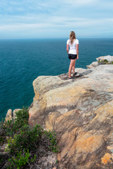 Fototapeta na wymiar Woman gazing out from the cliff top views Royal National Park