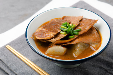 Braise in soy sauce meat in a white ceramic dish