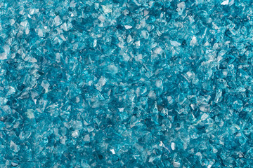 Texture of shattered blue glass fragments. Background of sharp glass pieces ready to be remelted.