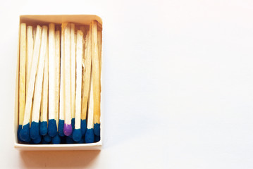 Blue matches and one match of purple color in a box. Difference, self respect and acceptance concept. Copyspace on the right side of the image for designers. Uniqueness and individualism concept.
