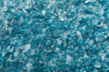 Shattered blue glass fragments, selected focus with depth of field. Background of sharp glass pieces ready to be remelted.