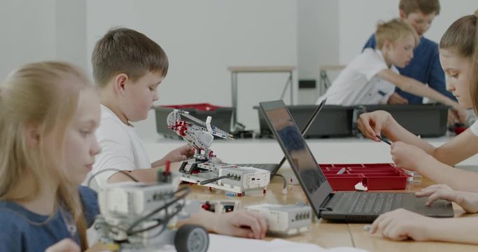 Curious kids working on a functional programable robot during robotics class at school. 4K UHD 60 FPS SLOW MOTION