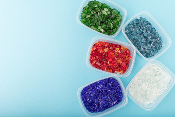 Broken glass sorted by color in plastic package with copy space. Recycling glass waste for creativity and crafts. Raw materials for handmade.