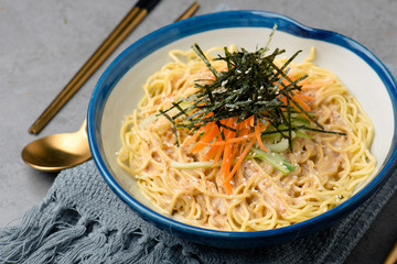 Mix noodles with dried seaweed in a ceramic dish