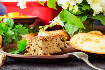 A piece of liver paste with greens on a background of jasmine.