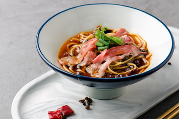 Spicy beef noodles in a white ceramic dish