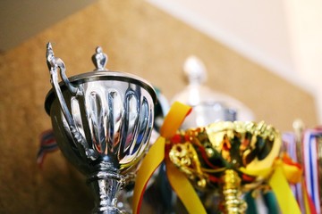 Silver trophy on shelf interior blur wall background