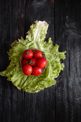 fresh red tomatoes, a source of useful vitamins and minerals are on the leaves of lettuce