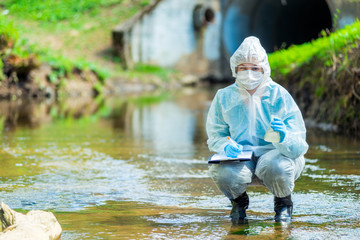 researcher scientist in protective clothing on the nature of conducting research on water