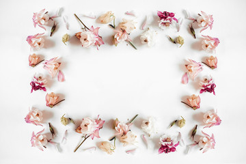 Rectangular frame made of pink and beige bell flower, green leaves, branches on white background. Flat lay, top view. Valentine's and women's Day.