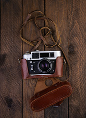 Vintage old camera on rustic wooden background. Top view
