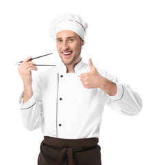 Handsome male chef with chopsticks on white background