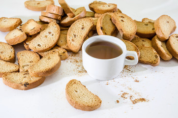 rusks with raisins on a white background and a cup of tea.