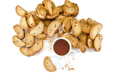 rusks with raisins on a white background and a cup of tea. View from above.