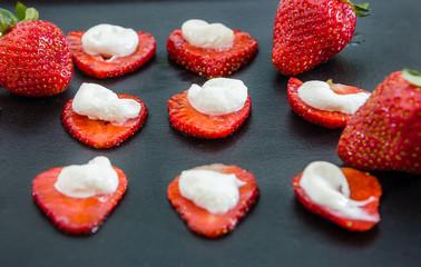 Delicious strawberries with cream on a black background. Background with strawberries.