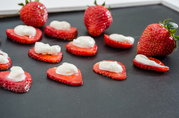 Delicious strawberries with cream on a black background. Background with strawberries.