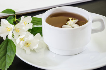 Obraz na płótnie Canvas cup of tea with jasmine on a black background, close-up