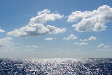 Blue sky with white clouds over the azure waters of the ocean.