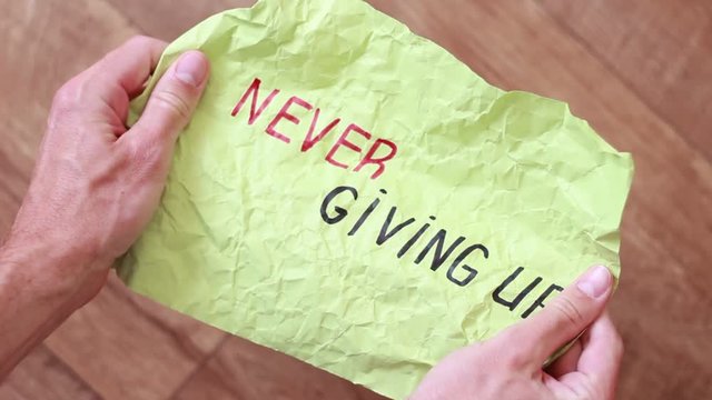 Unfolding sheet with "Never giving up" inscription