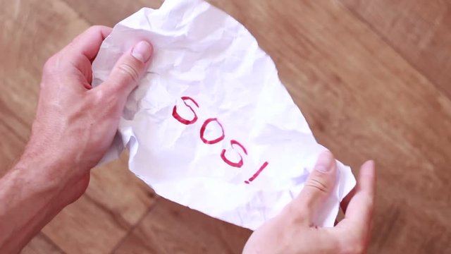 Unfolding rumpled sheet with "SOS" inscription