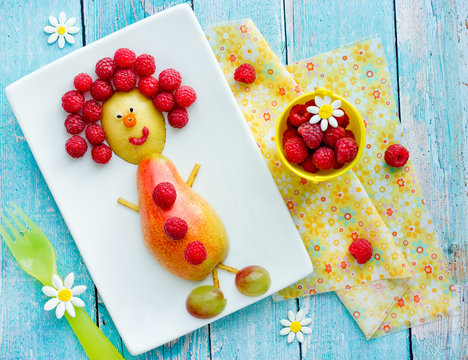 Food art idea for kids - pear and raspberry funny man, healthy snack from fruits and berries