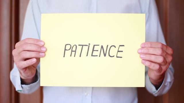 "Patience" inscription holding in male hands